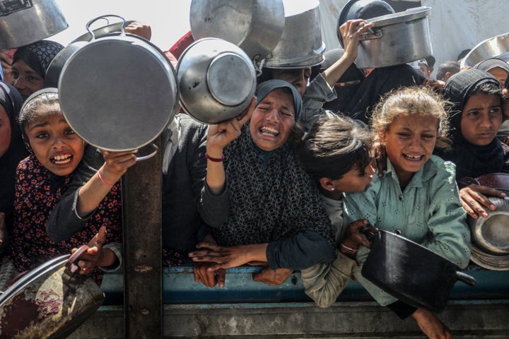 Displaced Palestinians receive meals distributed in the Mawasi area of Khan Younis, Gaza, on April 29, 2025. As Israel's relentless and devastating attacks on the Gaza Strip continue, Israeli policies have exacerbated the already severe humanitarian crisis in the region.