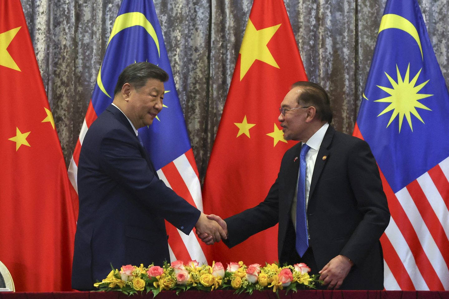 China's President Xi Jinping (left) and Malaysia's Prime Minister Anwar Ibrahim shake hands at the end of an Exchange of Agreement session at the official residence of the prime minister in Putrajaya outside Kuala Lumpur on April 16, 2025.