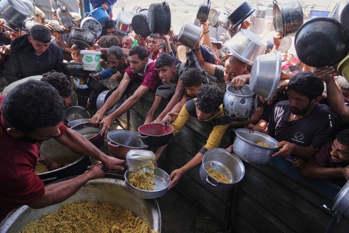 Palestinians struggle to get donated food at a community kitchen in Khan Younis, Gaza Strip, Friday, May 16, 2025. (AP Photo/Abdel Kareem Hana)