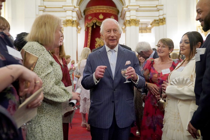 King Charles speaks to guests during a reception in celebration of community-based initiatives raising awareness about cancer and supporting those living with cancer Wednesday at Buckingham Palace in London.