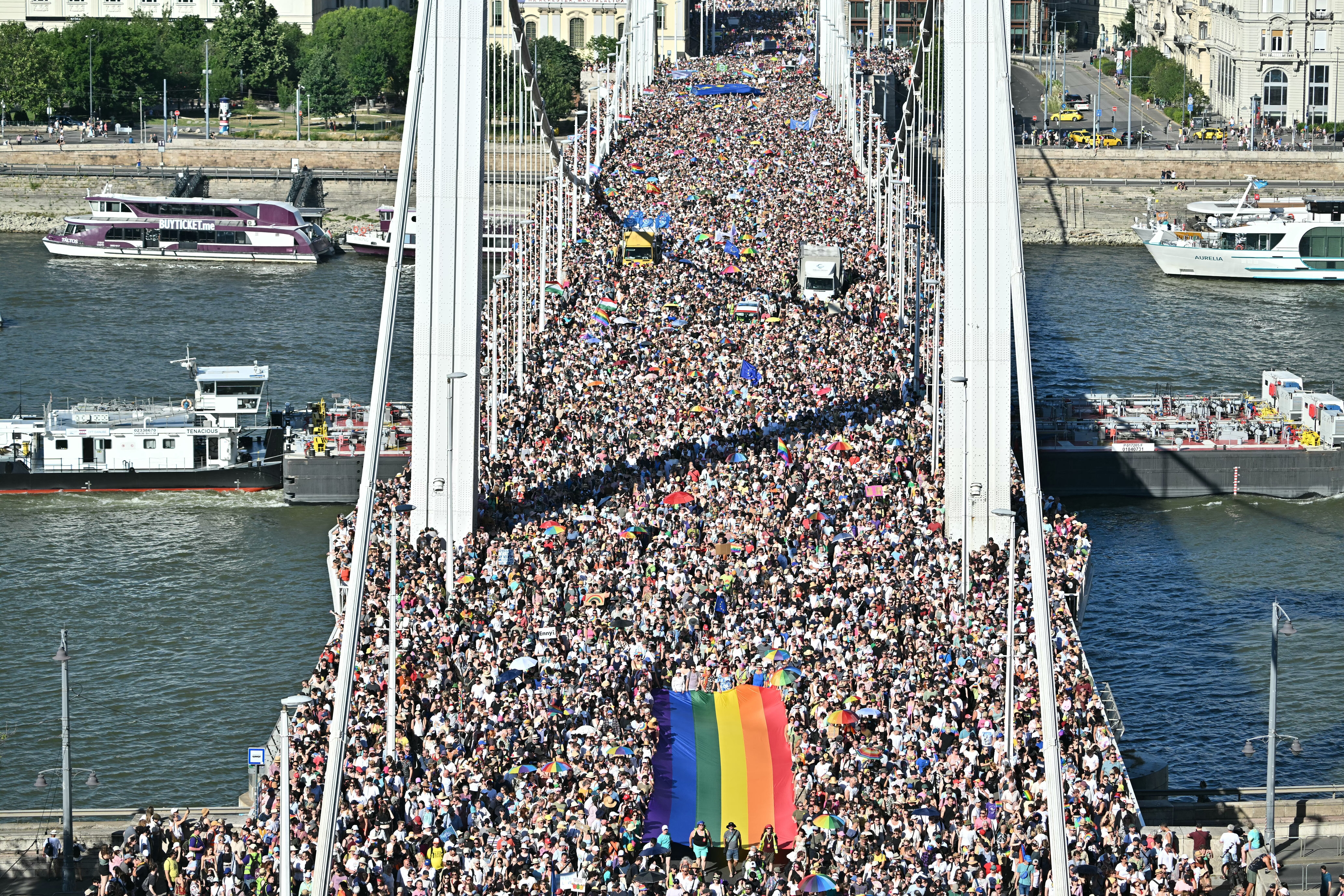 People carry a Rainbow flag as they take part in the Budapest Pride parade in Budapest downtown on June 28, 2025, as the capital's municipality organised this march by the LGBTQ community, celebrating freedom, in a move to circumvent a law that allows police to ban LGBTQ marches. (Photo by ATTILA KISBENEDEK/AFP via Getty Images)
