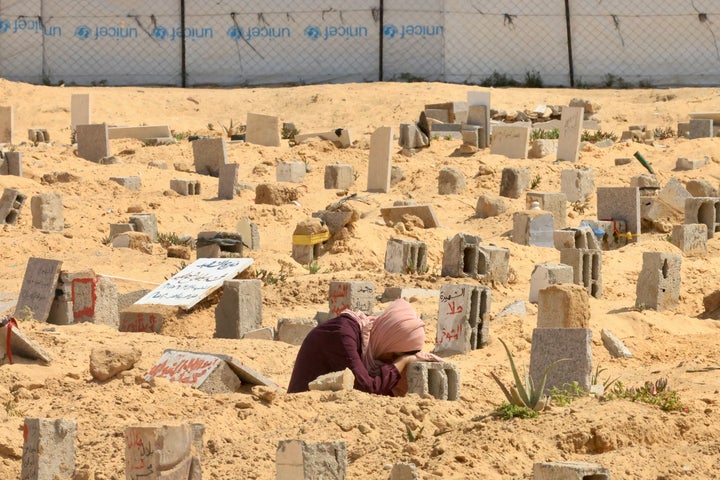 A Palestinian woman mourns over a relative's grave in Khan Younis, Gaza.