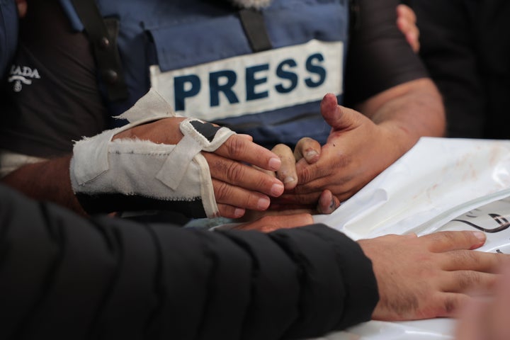 Al Jazeera's Gaza bureau chief Wael Al-Dahdouh holds the hand of his son, Al-Jazeera cameraman Hamza Al-Dahdouh, who was killed alongside freelance video journalist Mustafa Thuraya, who also worked for AFP, in an Israeli drone strike in early 2024.