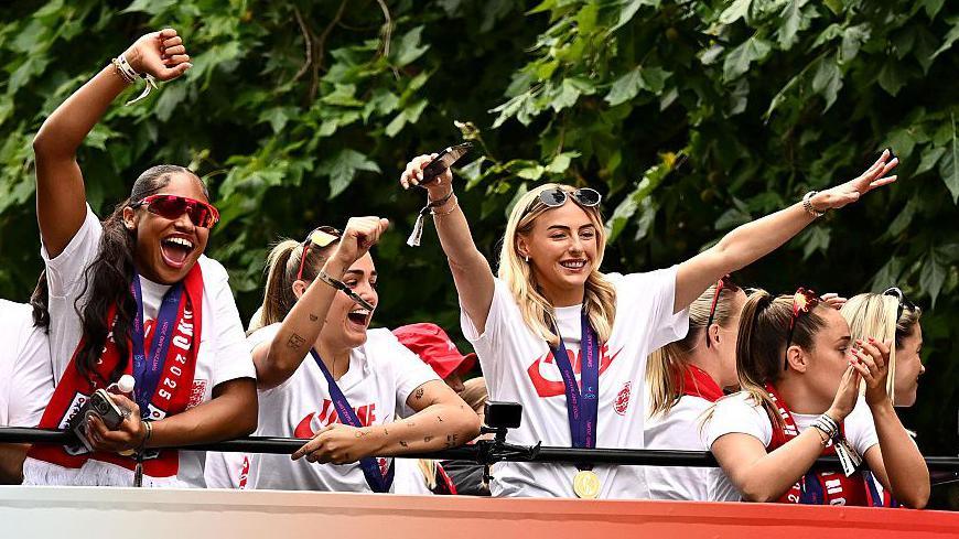 Khiara Keating, Georgia Stanway and Chloe Kelly celebrate during England's Euro 2025 bus parade