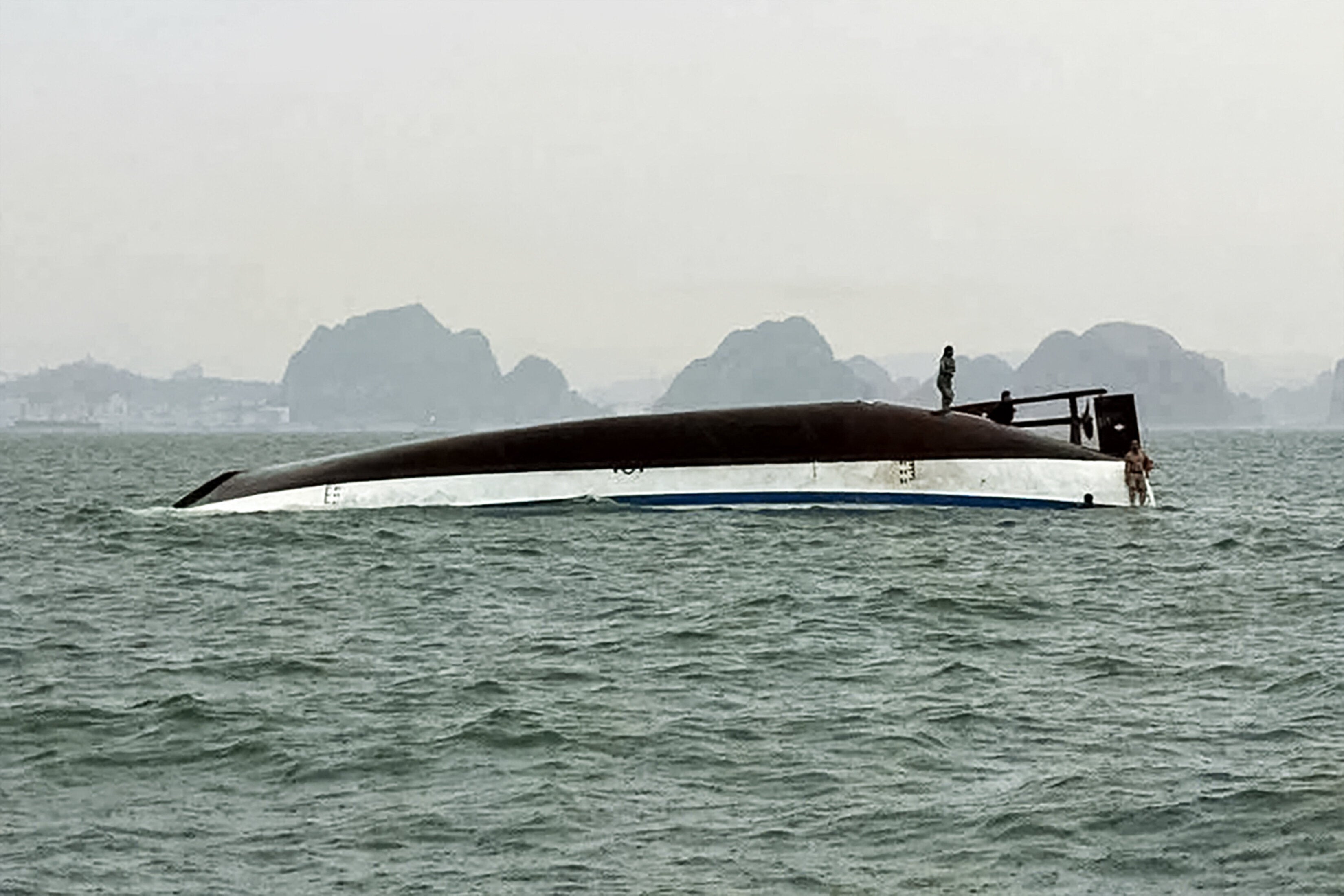 A man stands on a tourist boat that capsized in Ha Long Bay, Quang Ninh province on July 19, 2025. (Photo by AFP via Getty Images)