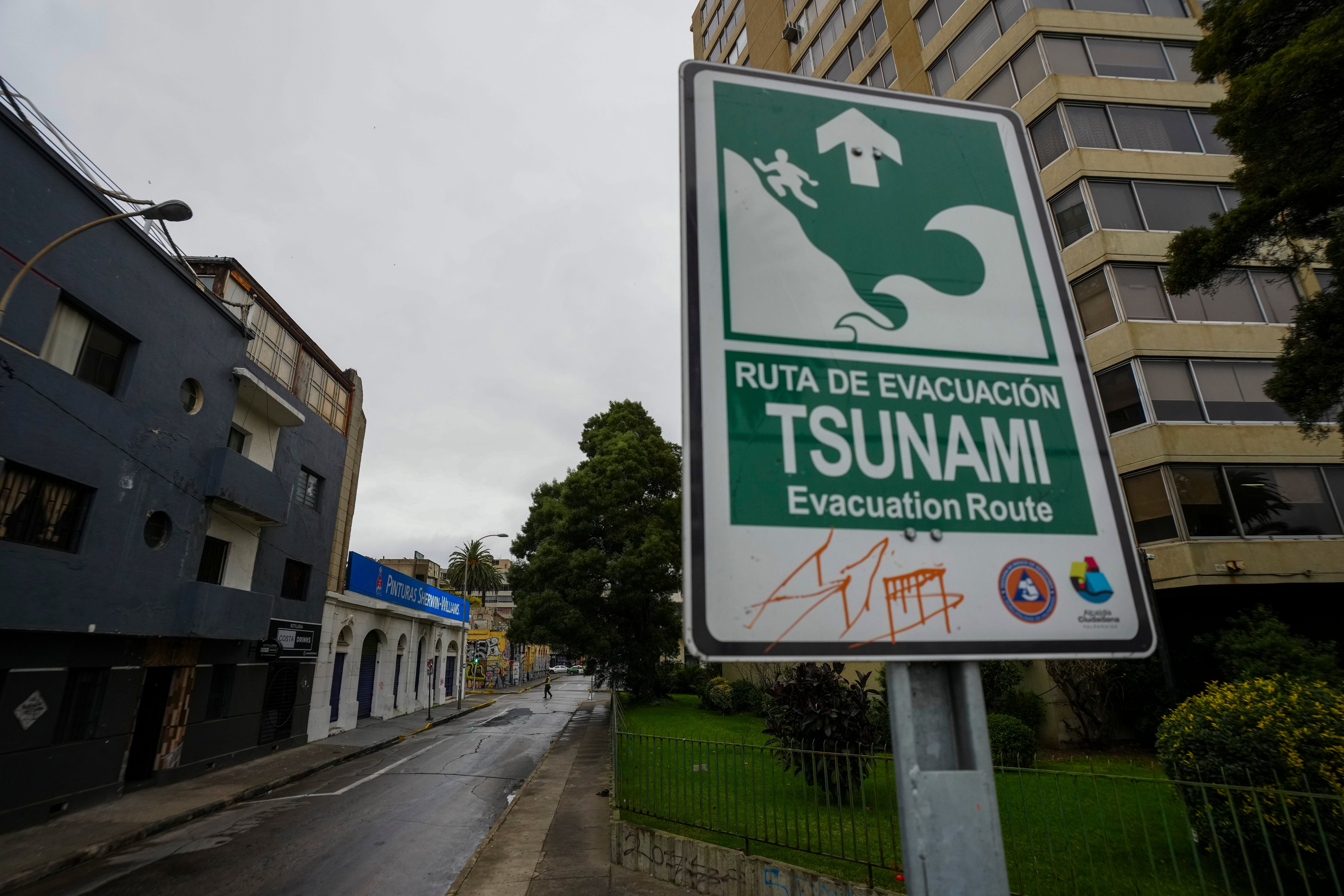 An evacuation route sign, in case of a tsunami, stands in Valparaiso, Chile, Wednesday, July 30, 2025, after an earthquake struck off the coast of Russia, triggering a precautionary tsunami warning. (AP Photo/Esteban Felix)