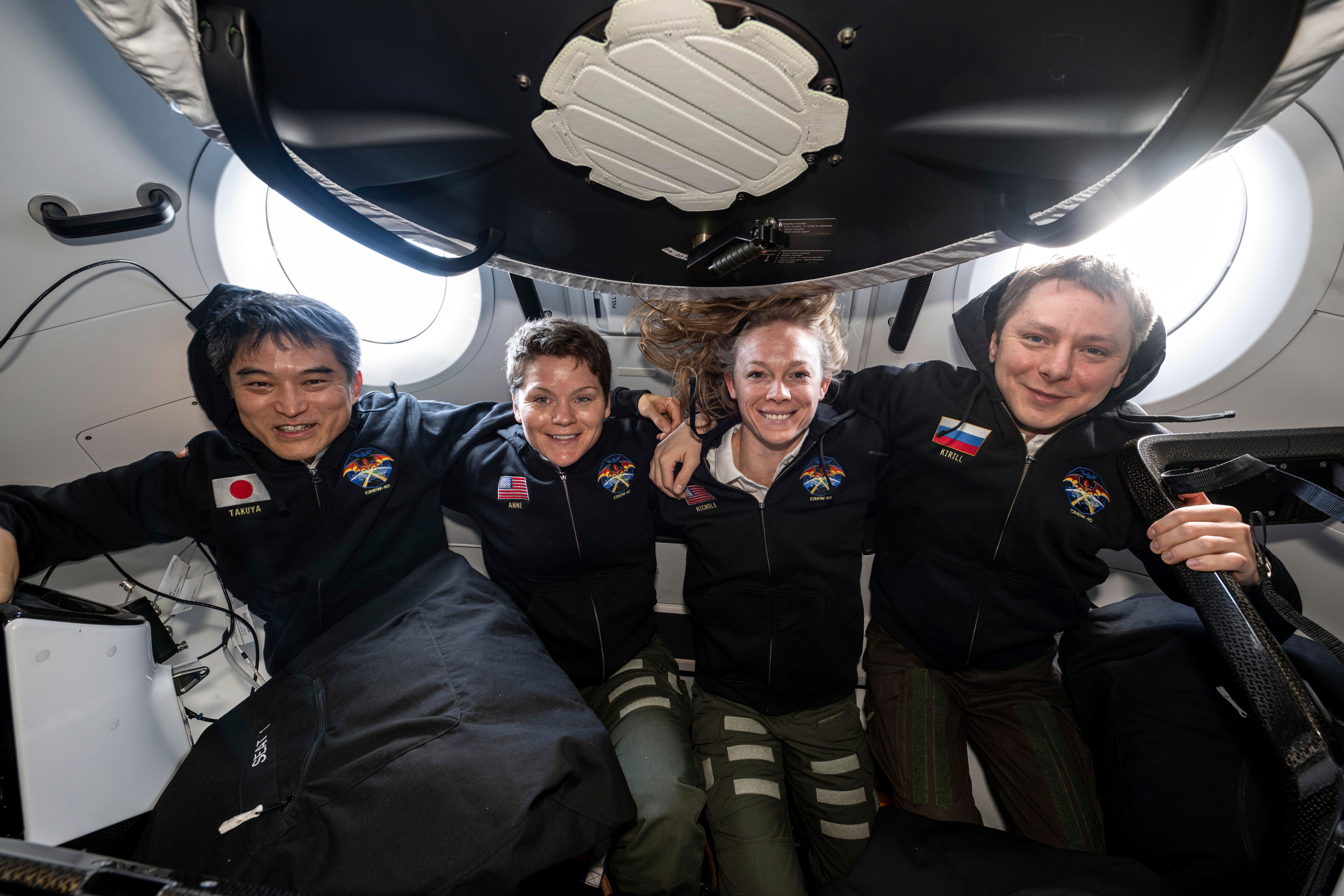 This image provided by NASA shows, from left, NASA's SpaceX Crew-10 members JAXA (Japan Aerospace Exploration Agency) astronaut Takuya Onishi, NASA astronauts Anne McClain and Nichole Ayers, and Roscosmos cosmonaut Kirill Peskov posing for a portrait inside the SpaceX Dragon crew spacecraft that carried them to the International Space Station and will return them back to Earth. (NASA via AP)