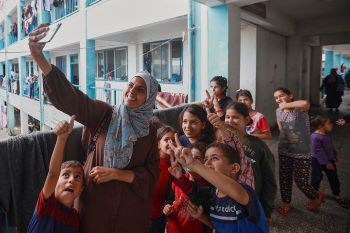 Palestinian journalist Mariam Dagga takes a selfie with children at a school in Khan Younis being used for shelter, in Gaza on Oct. 31, 2023. Dagga was one of several journalists killed in Israeli strikes on Nasser Hospital on Aug. 25, 2025.