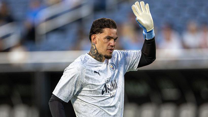 Ederson raising his hand during a pre-match warm up
