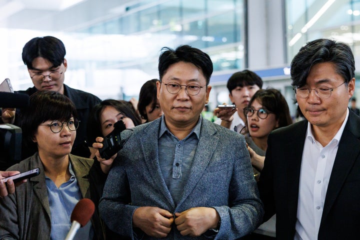 Kim Dong-Myung, chief executive officer of LG Energy Solution Ltd., center, is surrounded by members of media as he leaves the Incheon International Airport in Incheon, South Korea, on Friday, Sept. 12, 2025. (Photographer: SeongJoon Cho/Bloomberg via Getty Images)