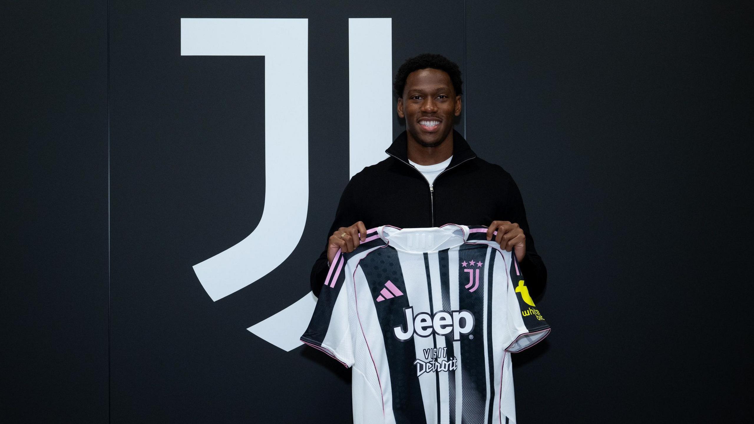 Jonathan David holds a Juventus shirt