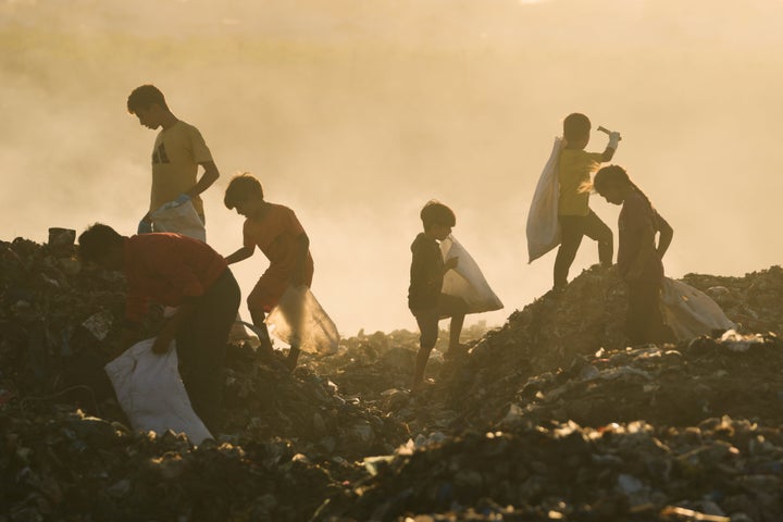 Displaced Palestinian children search for firewood and plastic in a landfill by a makeshift tent camp in southern Gaza's Khan Younis, on Sept. 30, 2025.