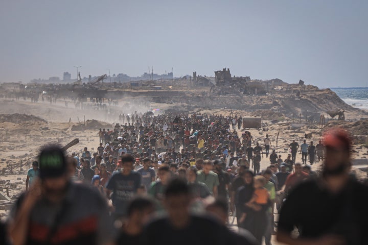 Palestinians walk along al-Rashid Street, the main coastal road connecting southern and central Gaza to the north, as they return to their homes following the new ceasefire agreement between Israel and Hamas in Gaza City, Gaza, on Oct. 10, 2025.
