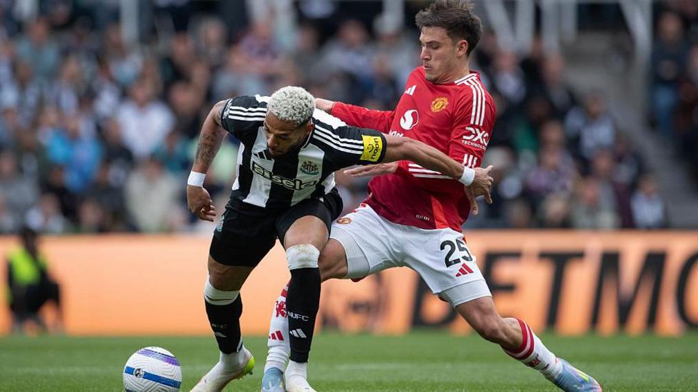 Joelinton of Newcastle United is challenged by Manuel Ugarte of Manchester United