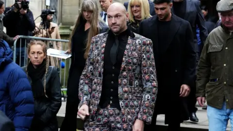 PA Media Tyson Fury is walking out of the funeral service for Ricky Hatton at Manchester Cathedral. His brother Tommy is walking behind him. 