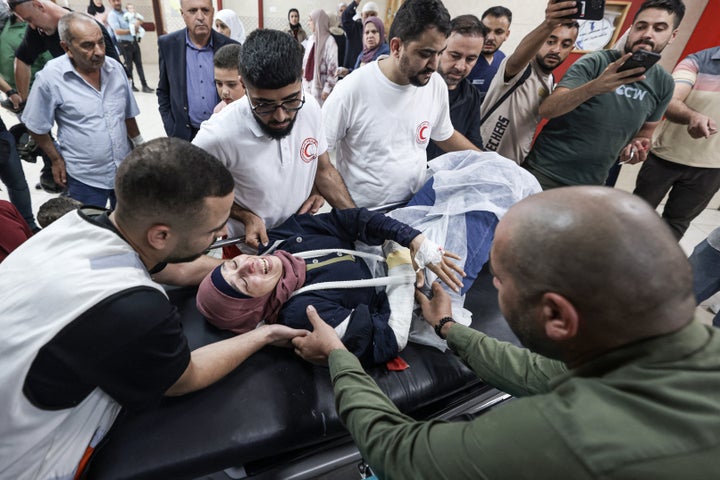 Palestinian photographer Raneen Sawafta reacts as she is carried on a stretcher at Rafidia Hospital in Nablus after reportedly being injured by Israeli settlers while covering the olive harvest in the Palestinian village of Baita, in the Israeli-occupied West Bank, on November 8, 2025. (Photo by JAAFAR ASHTIYEH/AFP via Getty Images)