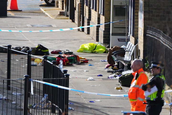 Belongings of escaping passengers are seen on the ground at the entrance to the train station after a mass stabbing on a London-bound train in Huntingdon, England, Sunday, Nov. 2, 2025.(AP Photo/Kirsty Wigglesworth)