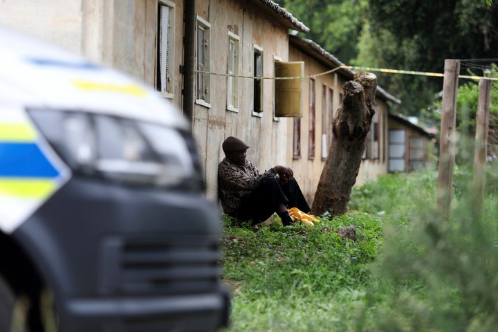 A man sits outside a scene where the bodies of the victims of a mass shooting were found, at a bar near Pretoria, South Africa, Saturday, Dec. 6, 2025. (AP Photo/STR)