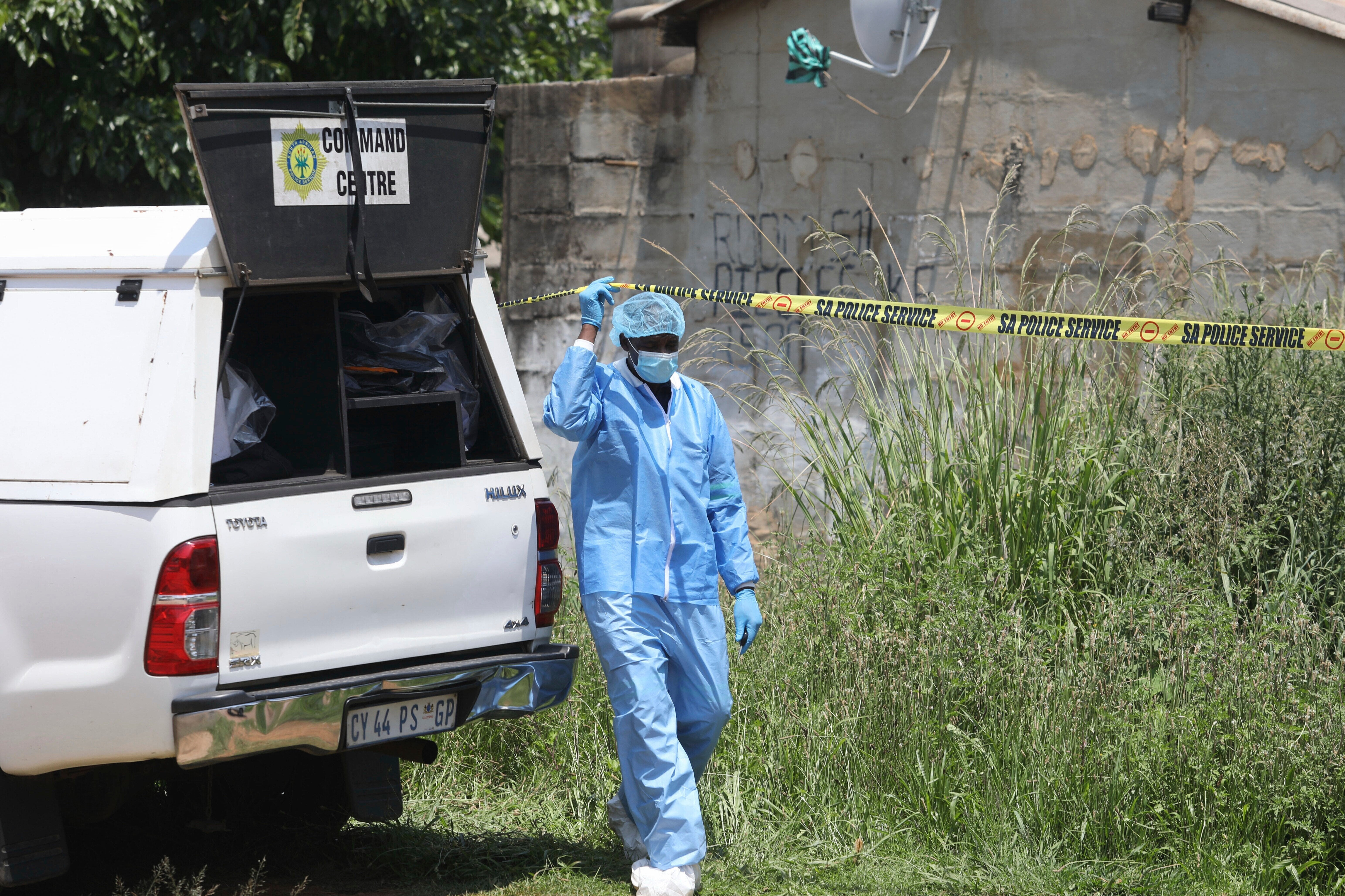Forensic personnel is seen at a scene where bodies of the victims of a mass shooting where found at a bar near Pretoria, South Africa, Saturday, Dec. 6, 2025. (AP Photo)