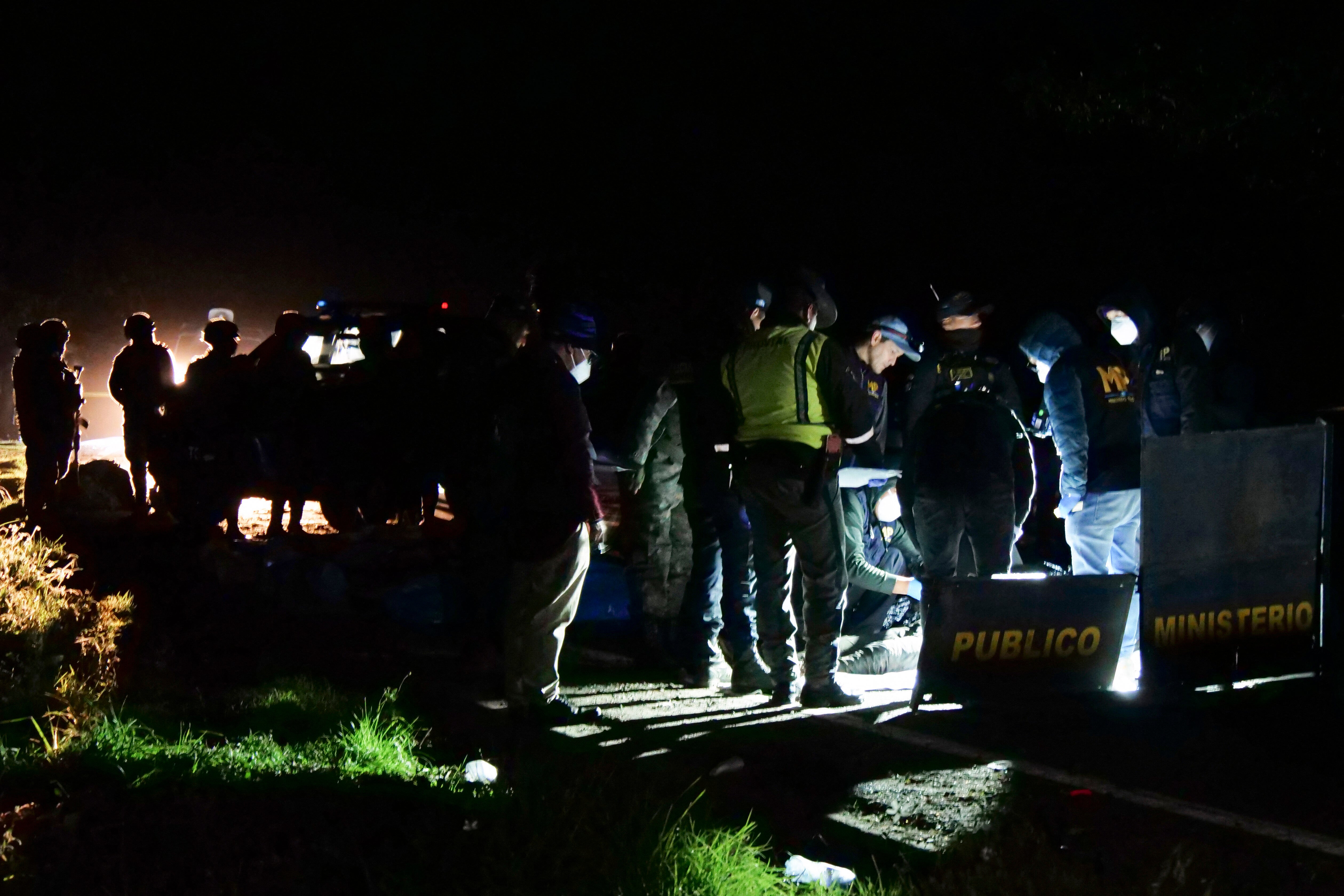 Members of the Public Prosecutor's Office work near the bodies of victims of a road accident at Cumbre de Alaska in Totonicapan, Guatemala, on December 27, 2025. (Photo by Gustavo RODAS / AFP via Getty Images)