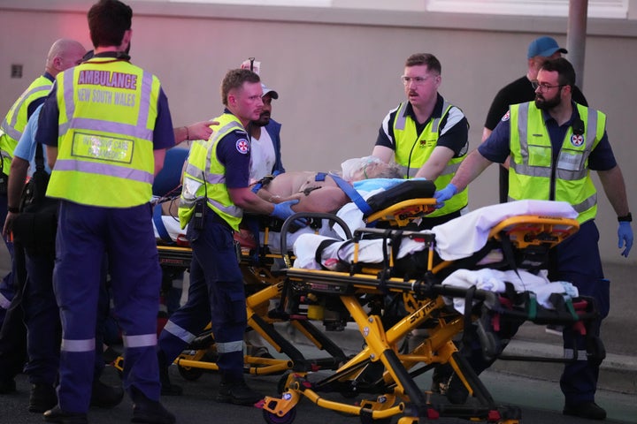 Emergency workers transport a person on a stretcher after a reported shooting at Bondi Beach in Sydney, Sunday, Dec. 14, 2025. (AP Photo/Mark Baker)