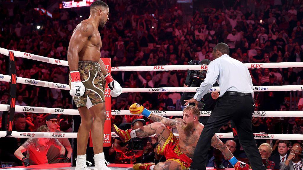 Anthony Joshua stands over Jake Paul on the canvas