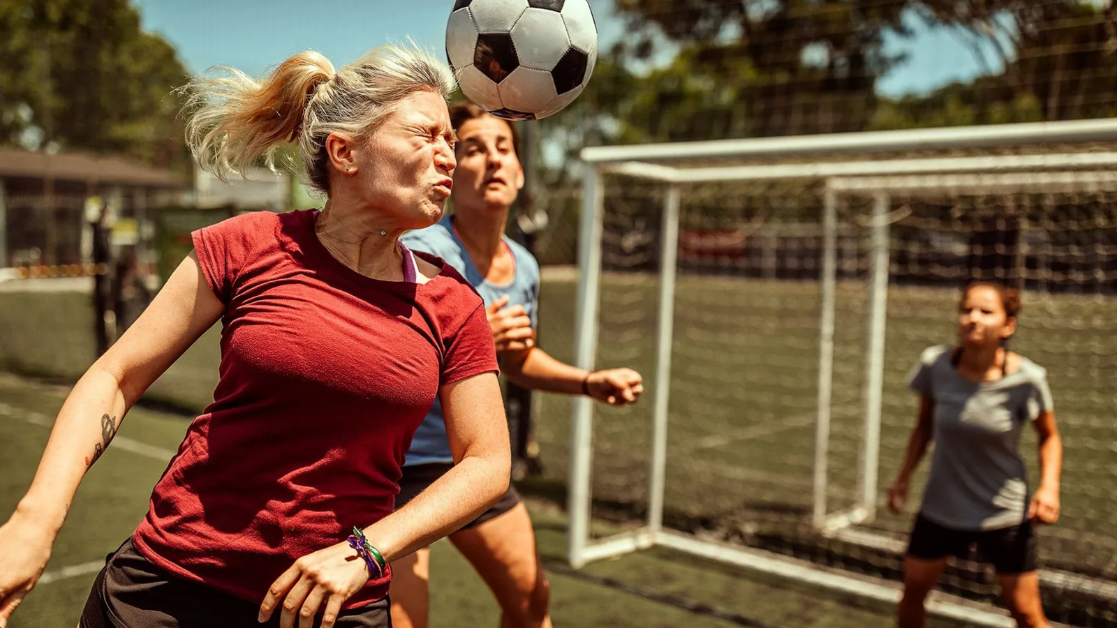 A stock image of a woman heading a football