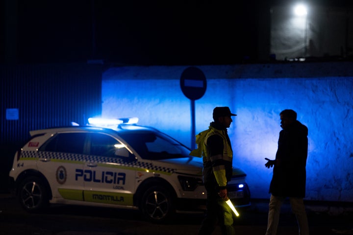 Spanish police officers stand near the site of a train accident in Adamuz, southern Spain, early on Jan. 19, 2026. Spain reeled from a collision between two high-speed trains in the southern region of Andalusia that killed at least 39 people, with the Prime Minister Pedro Sanchez lamenting a "night of deep pain" in the early hours of Jan, 19, 2026.