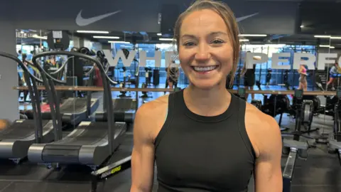 BBC Picture of a woman smiling in front of gym equipment