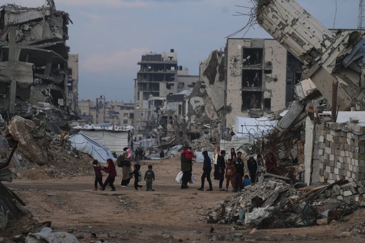 Palestinians walk amid buildings destroyed by Israeli air and ground operations in the Zeitoun neighborhood of Gaza City, Wednesday, Jan. 14, 2026. (AP Photo/Jehad Alshrafi)
