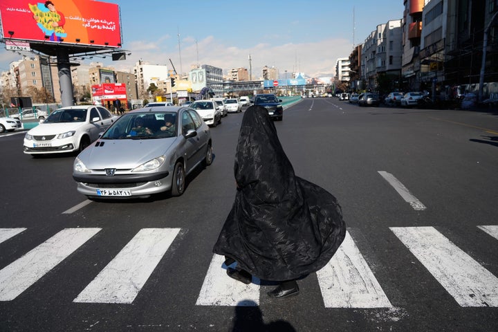 A woman crosses an intersection in downtown Tehran, Iran, Friday, Jan. 16, 2026. (AP Photo/Vahid Salemi)