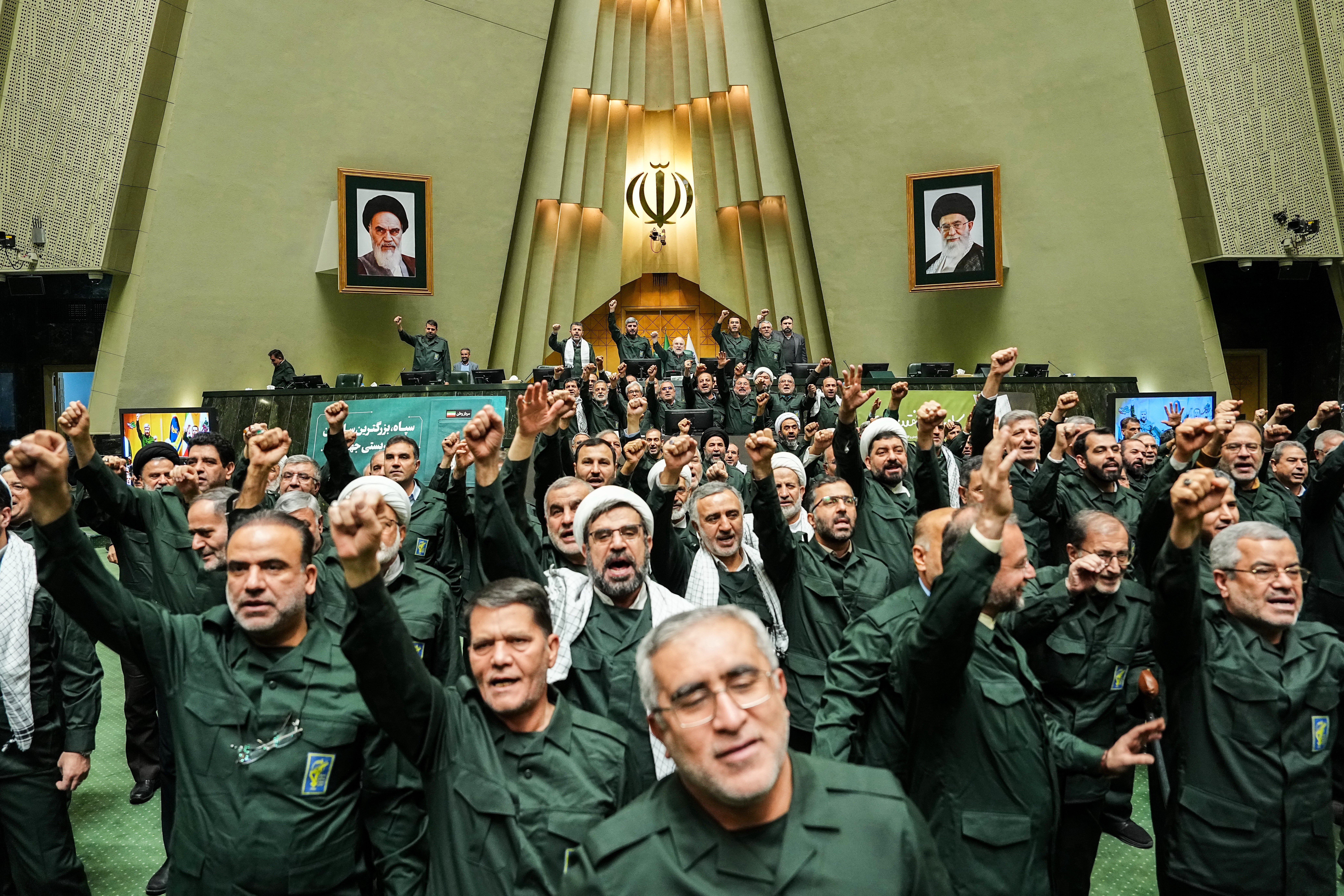 In this handout photo released by the Islamic Consultative Assembly News Agency (ICANA) Iranian lawmakers chant slogans as they wear the Revolutionary Guard's uniform in a session of parliament, in Tehran, Iran, Sunday, Feb. 1, 2026. (Hamed Malekpour/ICANA via AP)