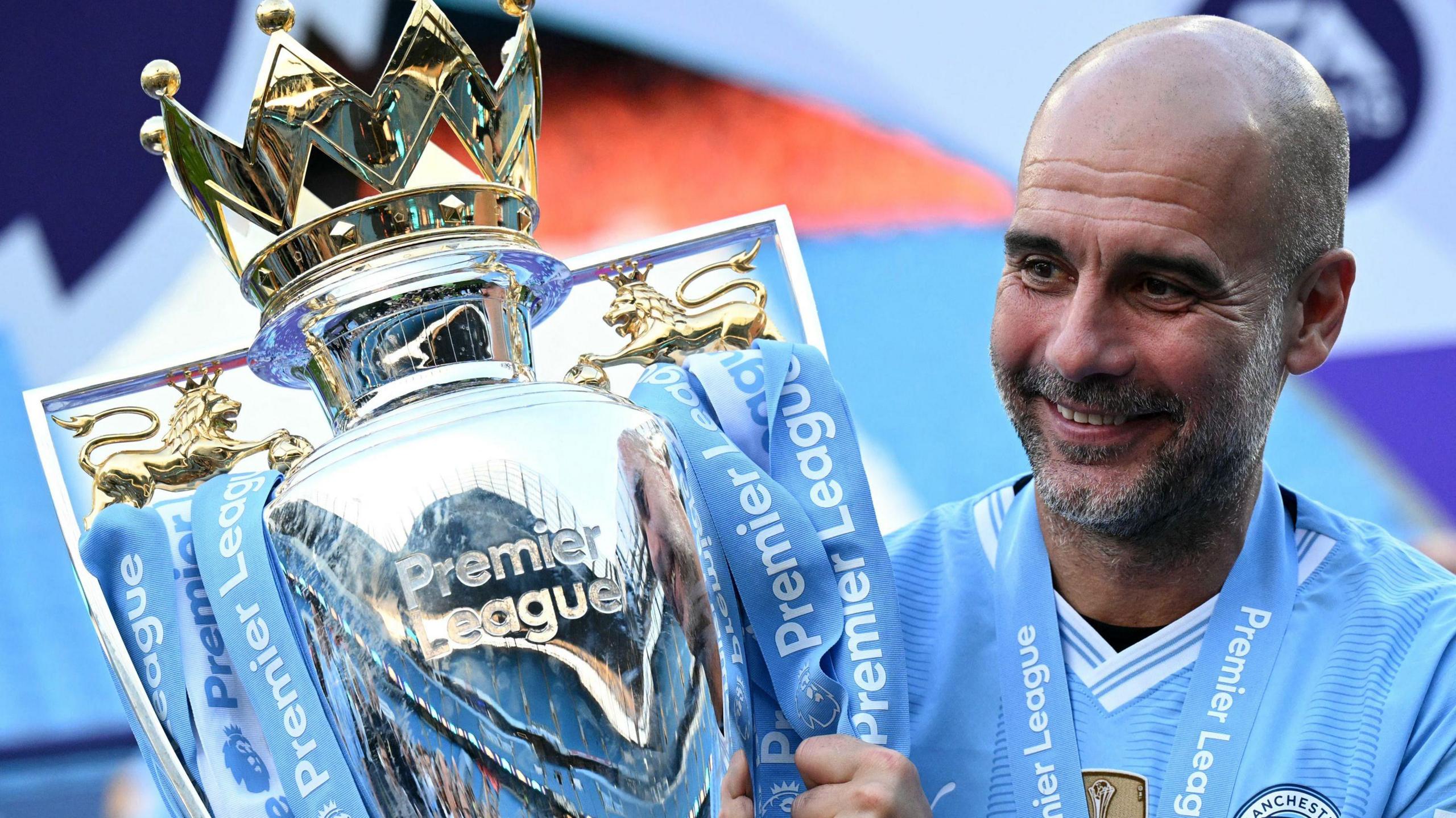 Manchester City manager Pep Guardiola holding the Premier League trophy
