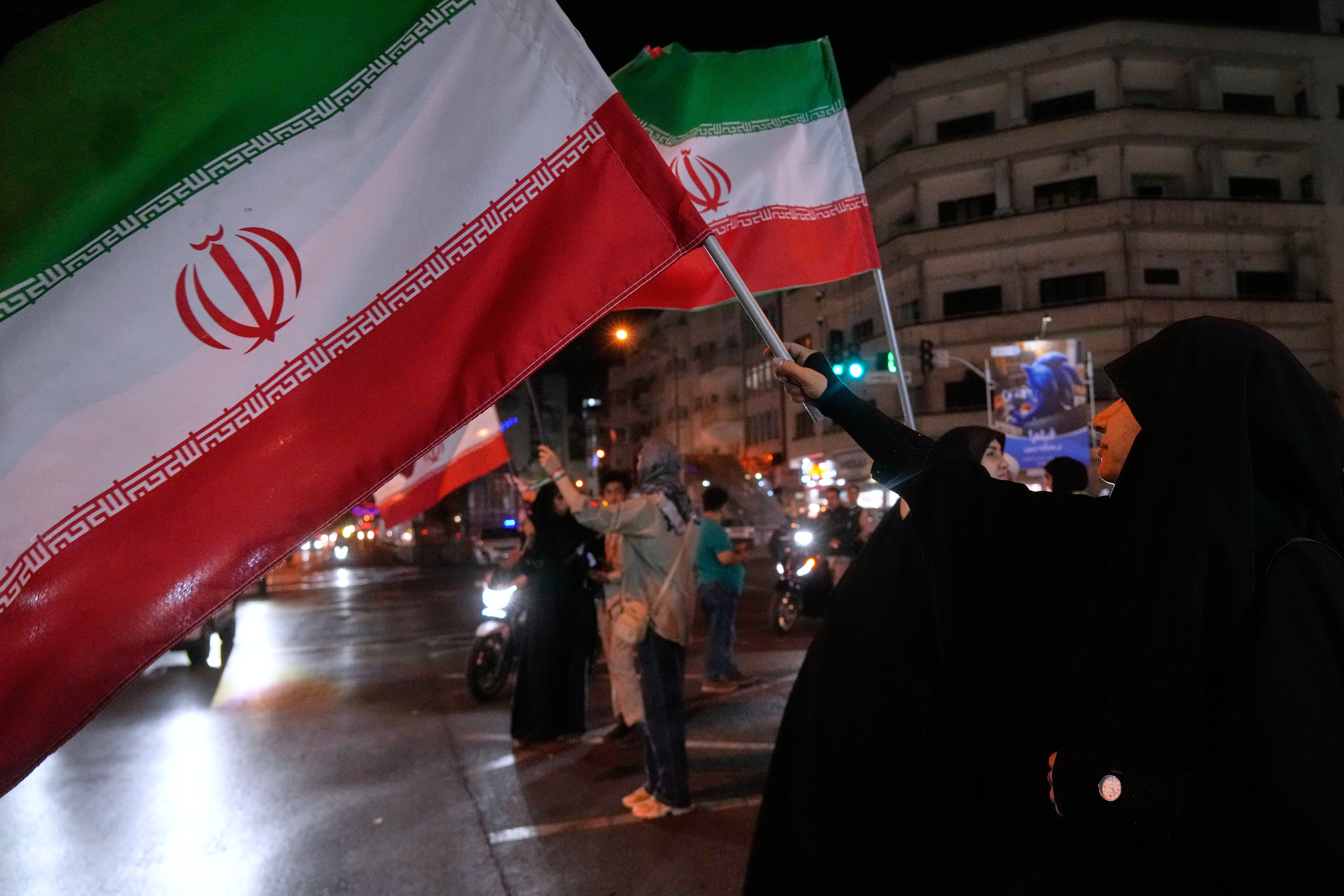 Women hold Iranian flags for a pro-government campaign in downtown Tehran, Iran, Friday, May 8, 2026. (AP Photo/Vahid Salemi)