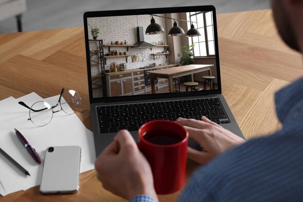 Man looking for house on real estate market website at table Man looking for house on real estate market website at table