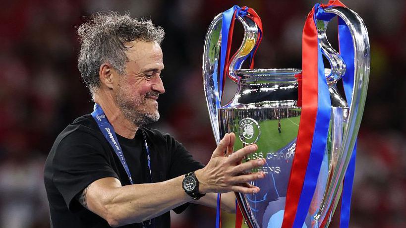 Paris St-Germain manager Luis Enrique smiling with the Champions League trophy