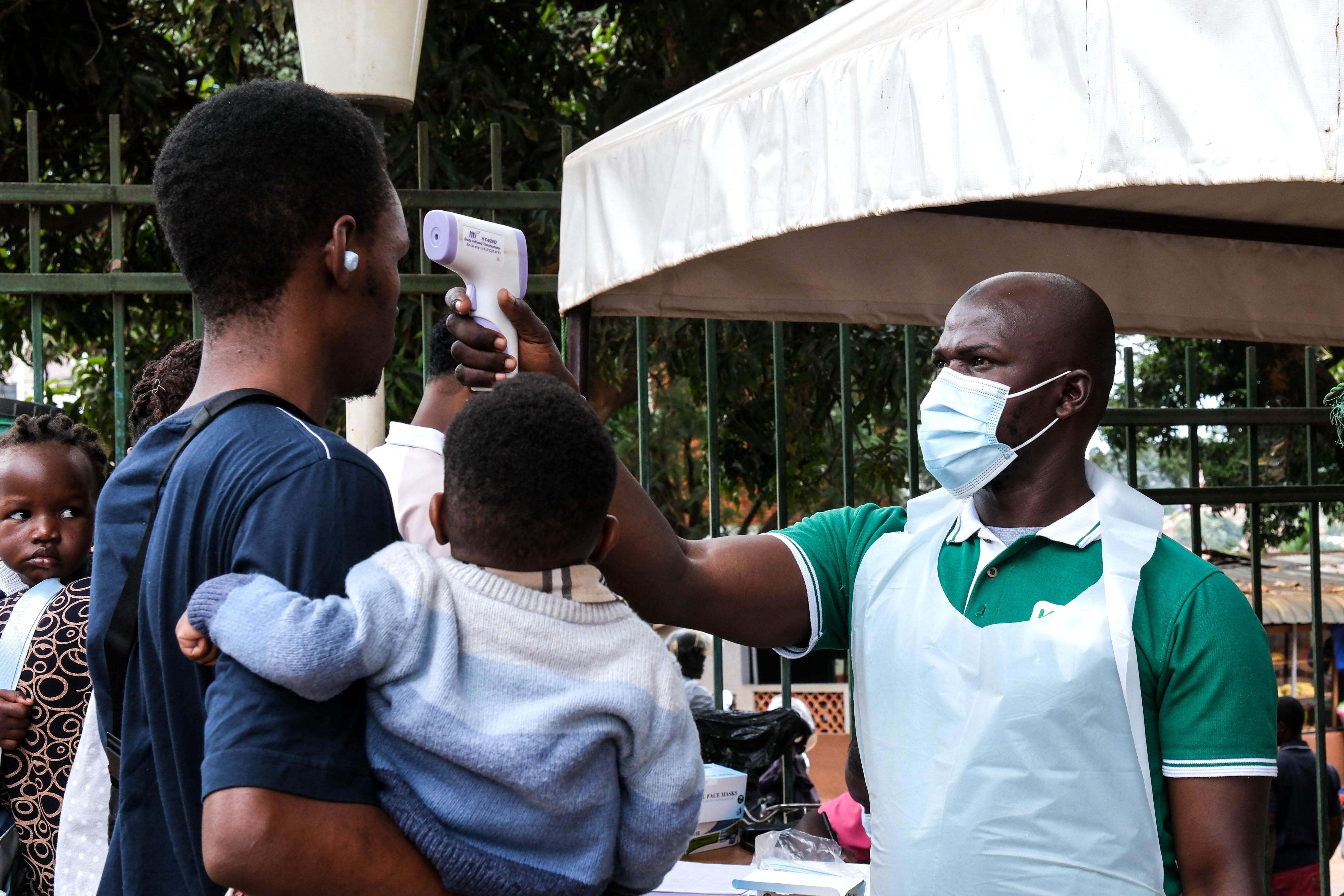 A health official uses a thermometer to screen people in front of Kibuli Muslim Hospital in Kampala, Uganda on May 16, 2026.