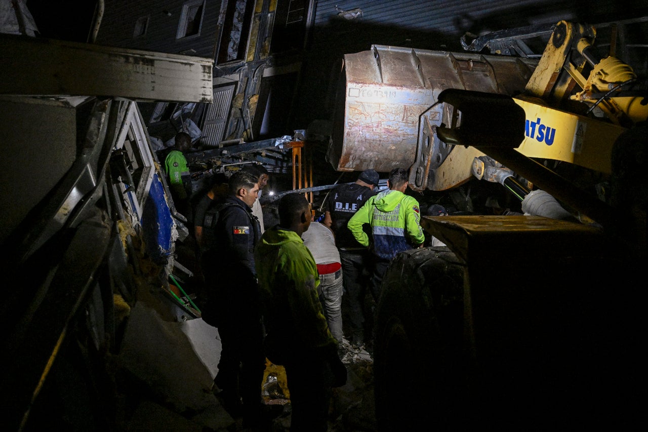 Police and volunteers search for people in a damaged building following an earthquake in Catia La Mar, La Guaira state, north-west of Caracas, early on June 25, 2026. 