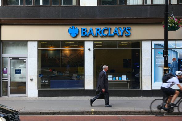 Person walks by Barclays Bank branch in London. Barclays is a large British financial group. Person walks by Barclays Bank branch in London. Barclays is a large British financial group.