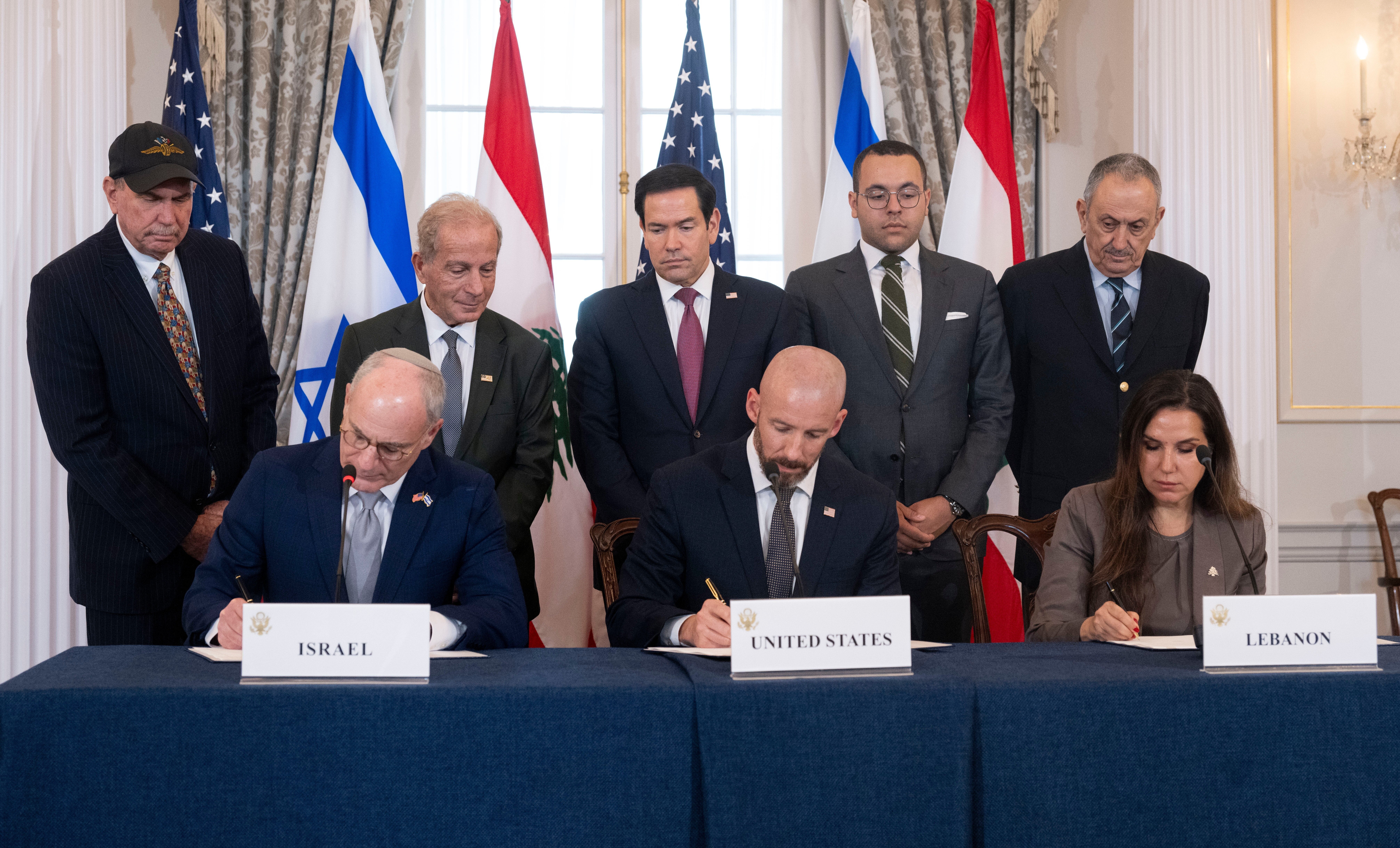Secretary of State Marco Rubio and others watch, seated from left, Israel's Ambassador to the U.S. Yechiel Leiter, counselor Dan Holler, and Lebanon's Ambassador to the U.S. Nada Hamadeh, sign a framework agreement, described as a first step toward peace following months of conflict between Israel and the Lebanese militant group Hezbollah, at the State Department, Friday, June 26, 2026, in Washington. (AP Photo/Kevin Wolf)