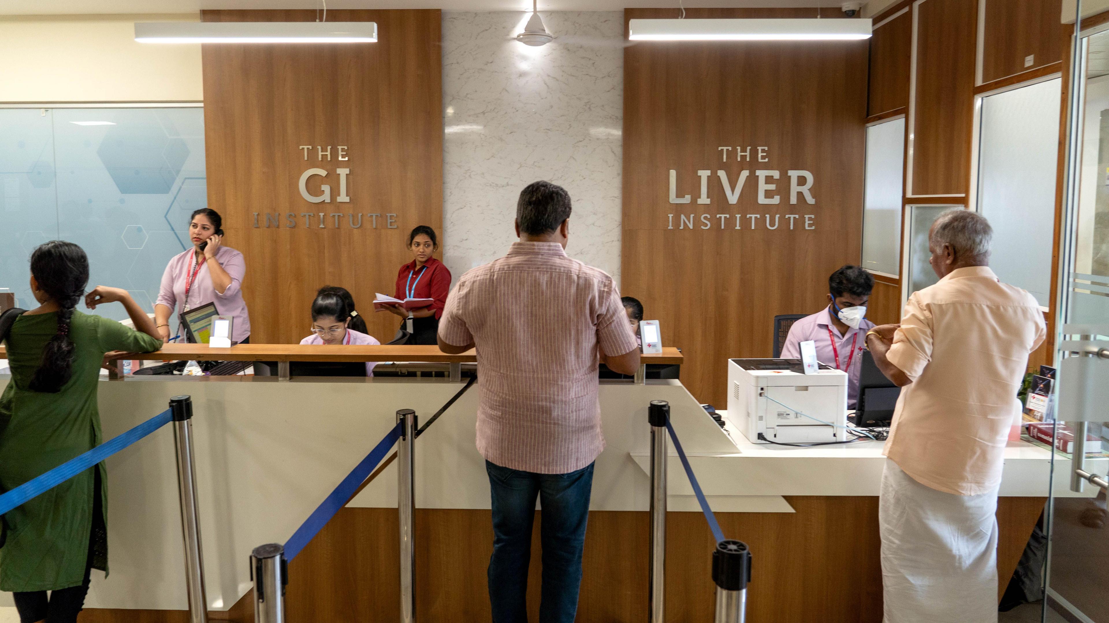 People standing at the reception counter of the Liver Institute in Kerala 
