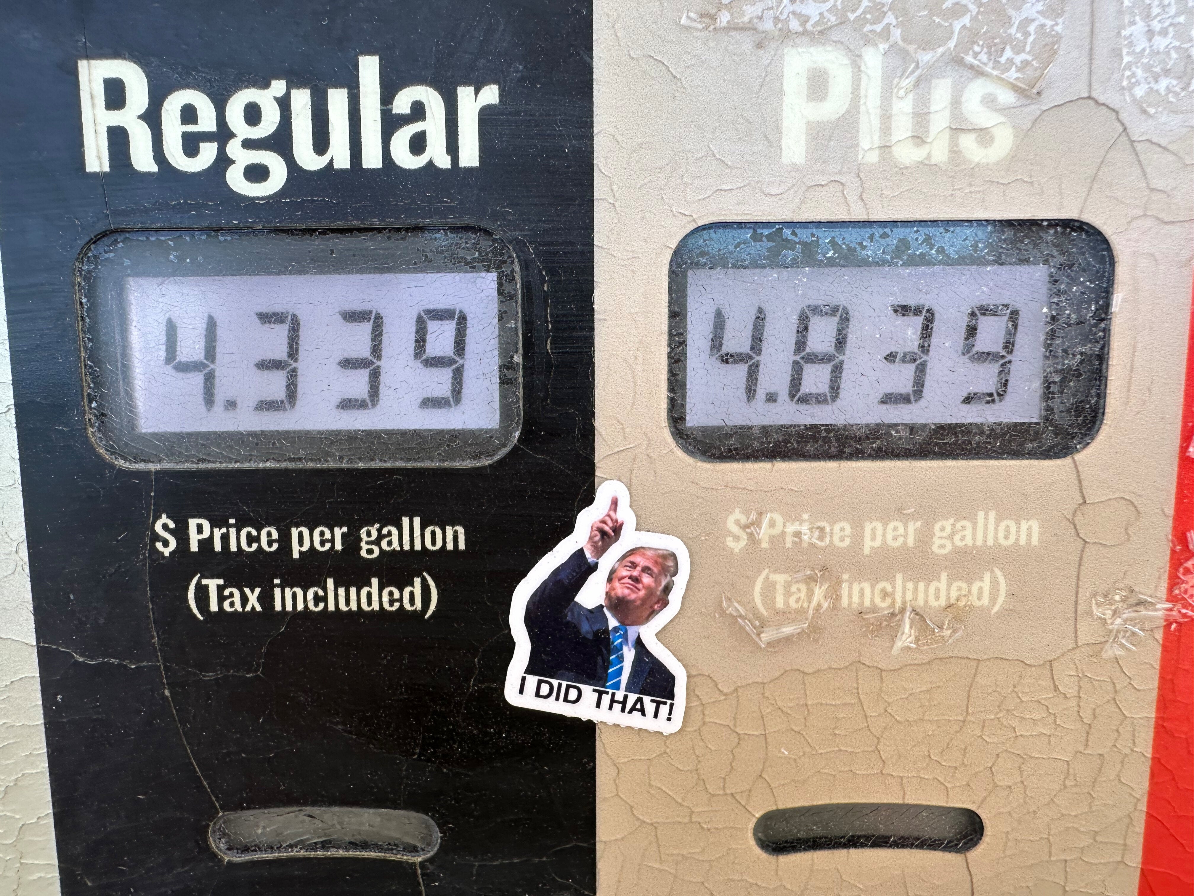A sticker of President Donald Trump points to the electronically-posted prices for a gallon of regular or regular plus gasoline available at a Conoco station Saturday, May 30, 2026, in Denver. (AP Photo/David Zalubowski)