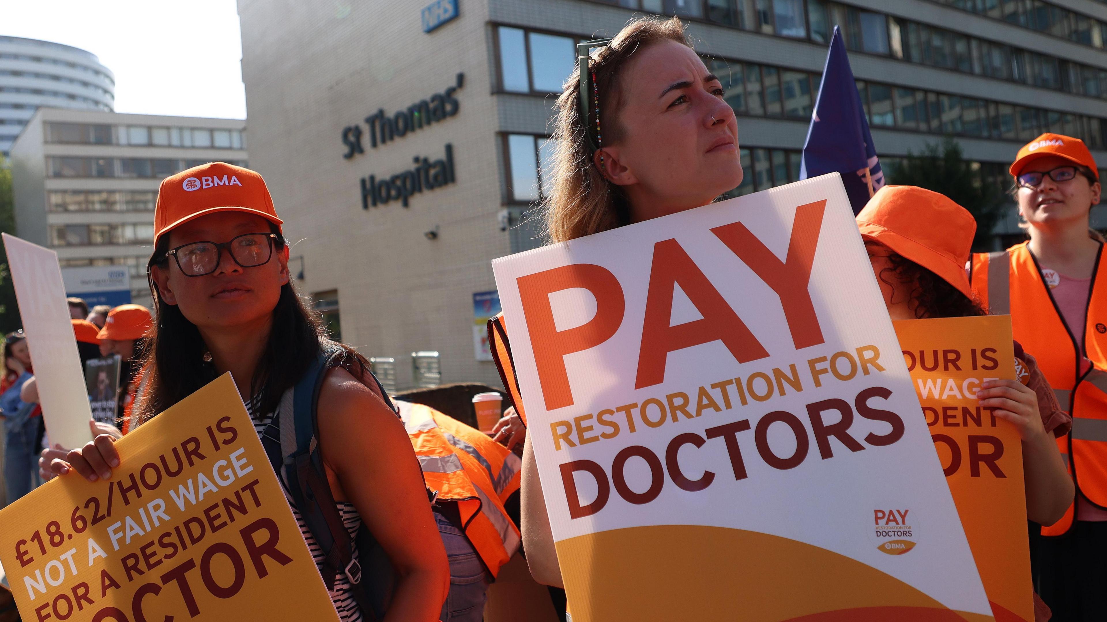 Resident doctors on strike hold placards outside St. Thomas's hospital in London