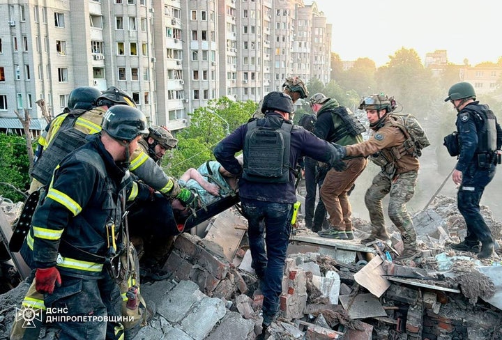 In this photo provided by the Ukrainian Emergency Services on June 2, 2026, rescue workers carry an injured woman on a stretcher from the rubble of a residential building destroyed after a Russian strike on Dnipropetrovsk region, Ukraine.