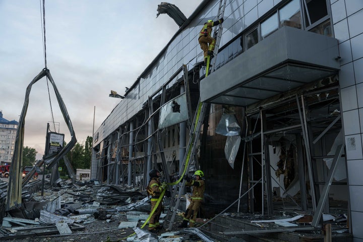 A rescue worker climbs to the roof of a car dealership damaged after a Russian strike on Kyiv, Ukraine, on June 2, 2026. Russia attacked Ukraine with a barrage of missiles and drones overnight, killing at least 11 people, injuring dozens and trapping others, authorities said.