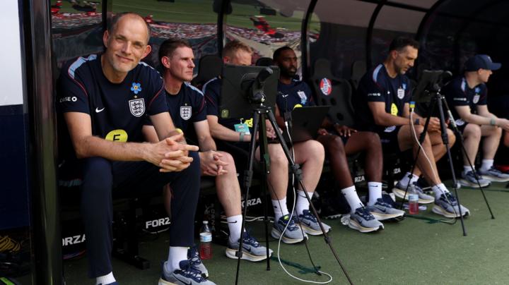 Thomas Tuchel and his England coaching staff seated in a dugout