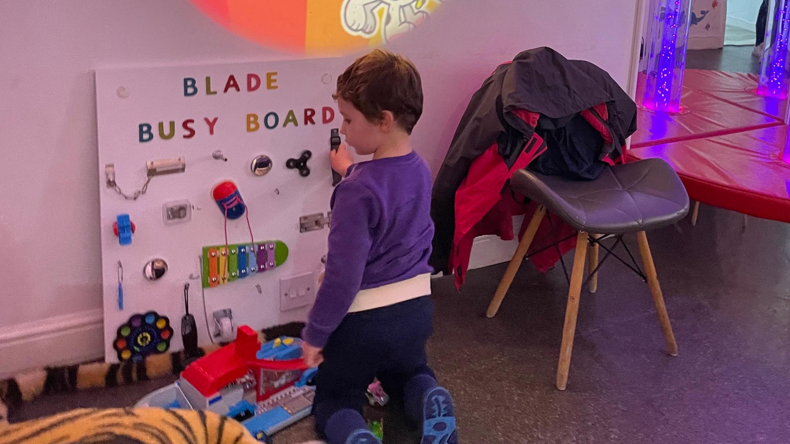 A young boy playing with a sensory board.