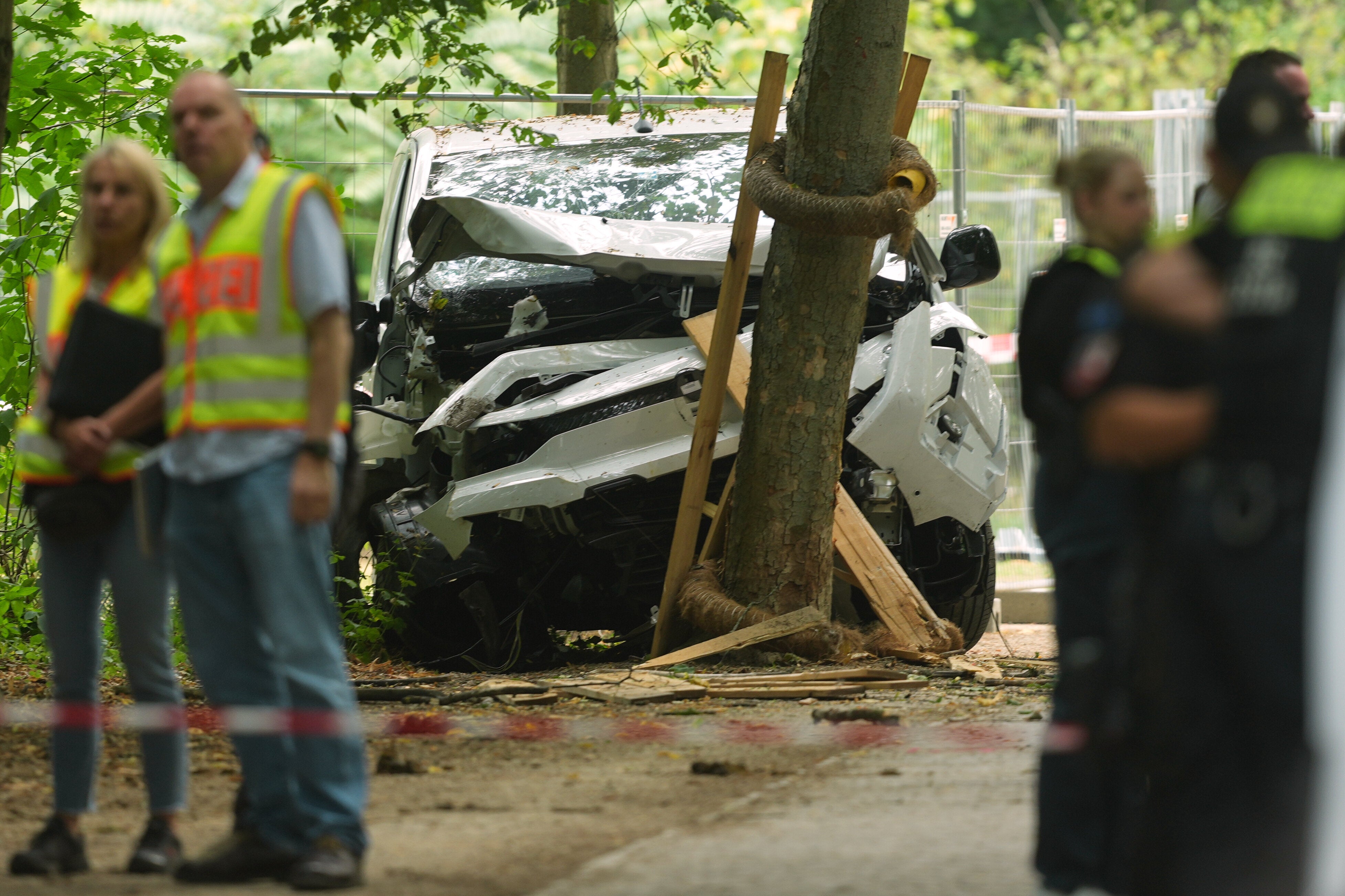 Police officers stand near a vehicle crashed into a tree in an a deadly attack on Berlin’s annual Pride event on Saturday. (AP Photo/Markus Schreiber)