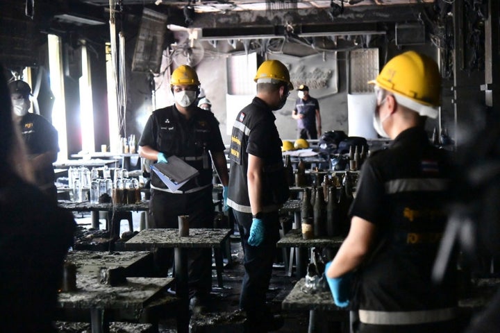 In this handout photo released by Bangkok Metropolitan Administration, forensic police officers inspect the site of a fire in Bangkok, Thailand, on July 13, 2026.