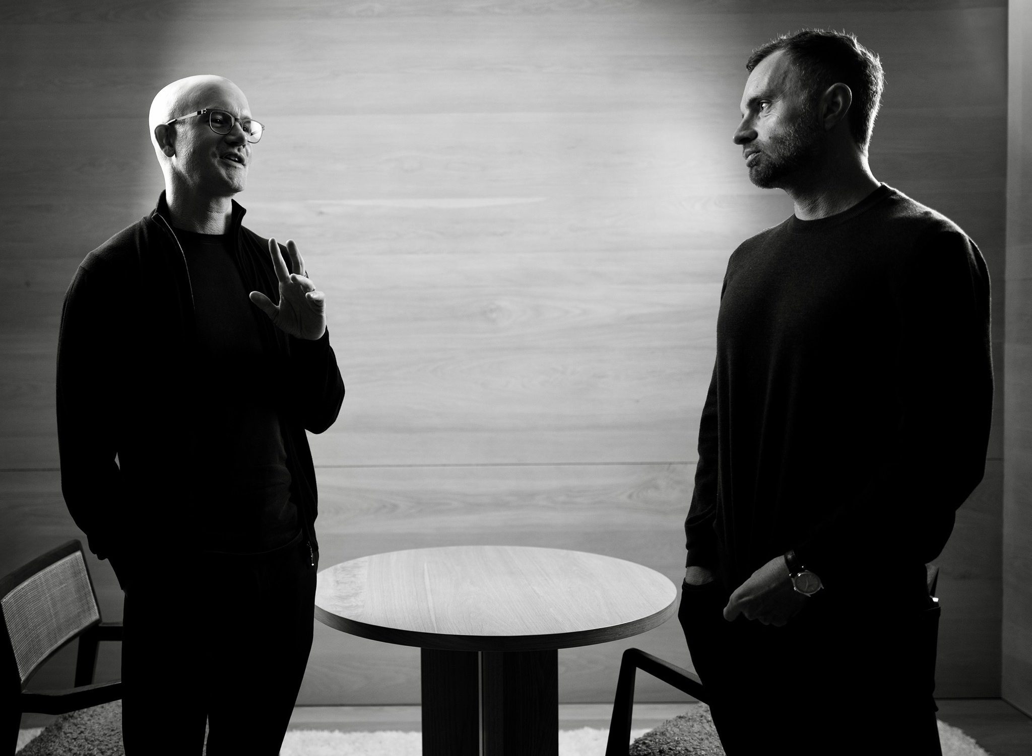 Brian Armstrong (left) and David Senra (right) stand next to each other talking.